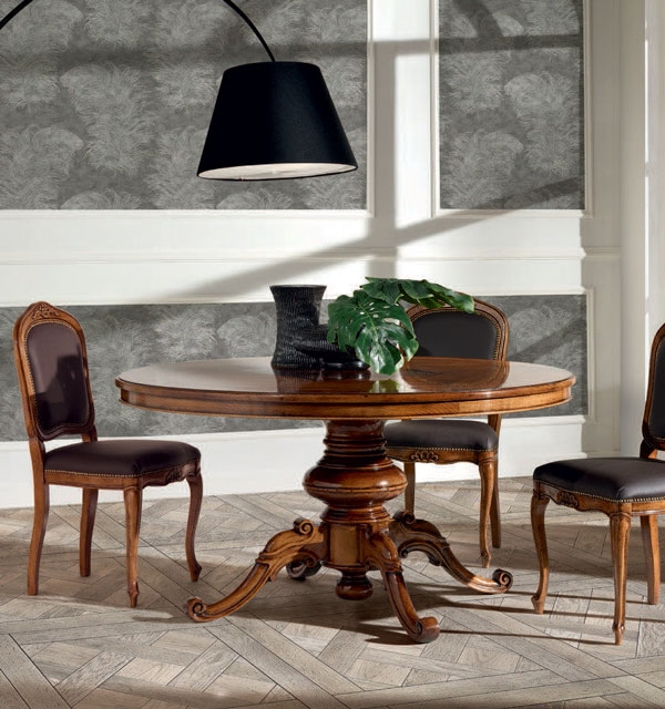 A Kerek fa asztal intarziával termékünknek nem csak az asztallapja, hanem a lábazata is különleges kialakítású.