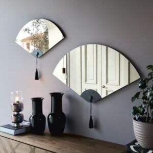 A Winderly tükör széles legyezőszerű tükörlapjával és az alján található például diófa vagy hőkezelt sötét tölgy berakással kelt elegáns hatást.